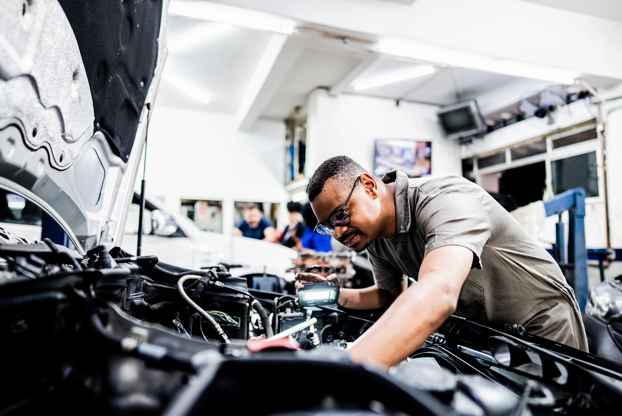 Mechanic installing an OEM component in a repair bay